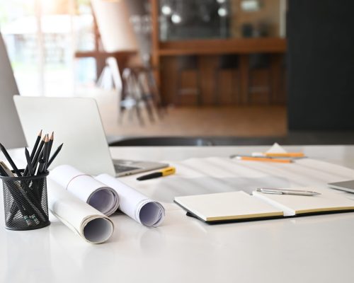 Architect  Office desk with blueprint, laptop computer, pencil on engineering workspace.