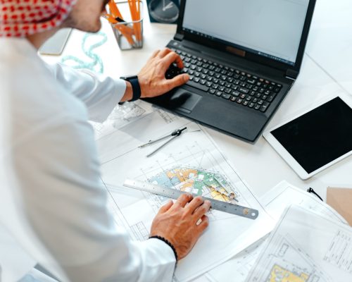 Young muslim businessman in traditional outfit working at the table in office clsoe up